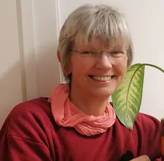 Lächelnde Frau mit langen braunen Haaren, Buntglas-Hintergrund.