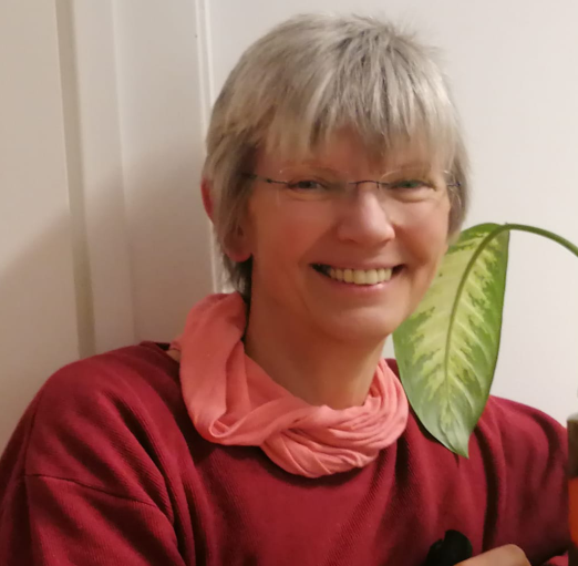 Lächelnde Frau mit langen braunen Haaren, Buntglas-Hintergrund.