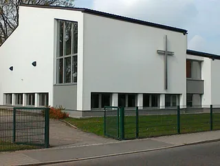 modernes Kirchengebäude in weiß mit Kreuz