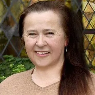 Lächelnde Frau mit langen braunen Haaren, Buntglas-Hintergrund.