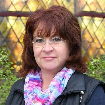 Lächelnde Frau mit Brille und Schal, Gemeindemitglied.